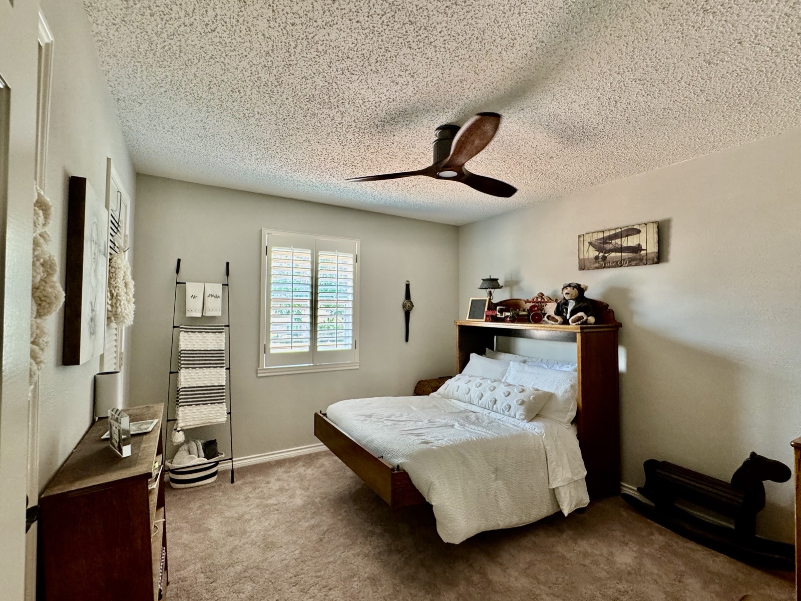 Guest bedroom with aviation art including Take Off sign and leather aviator memorabilia