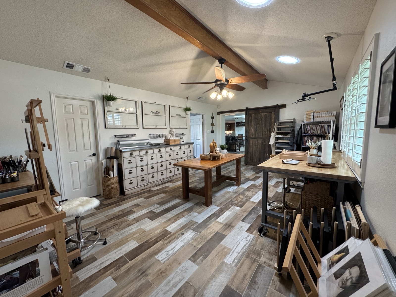 Fifth bedroom flex space with exposed beam ceiling and wood-look tile