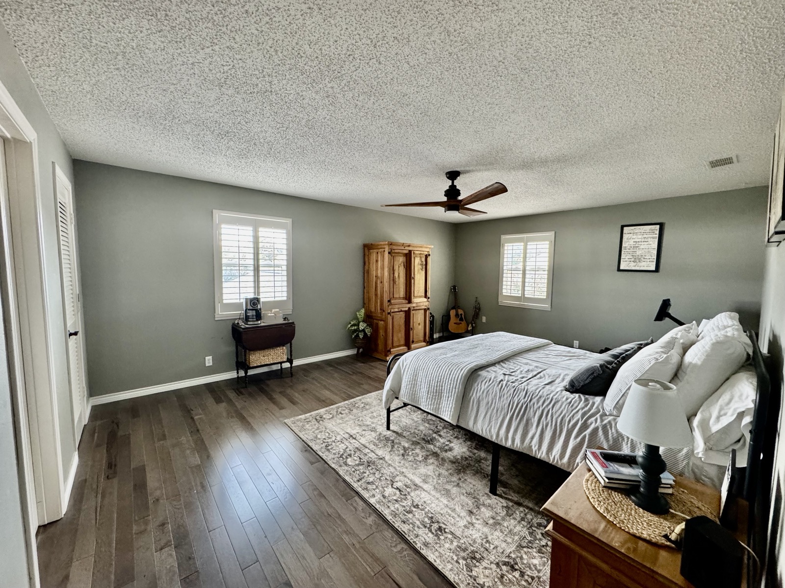Upstairs primary master suite with natural hardwood floors and plantation shutters